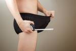 Adult Mann zieht seinen schwarzen Boxer mit einem Maßband in der anderen Hand. Konzept-Foto der männlichen Sexualität, Männlichkeit und Unsicherheit der Penisgröße. Lizenzfreie Bilder - 37043379